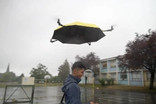 Uçan şemsiye kullanıcısını yağmurda takip ediyor