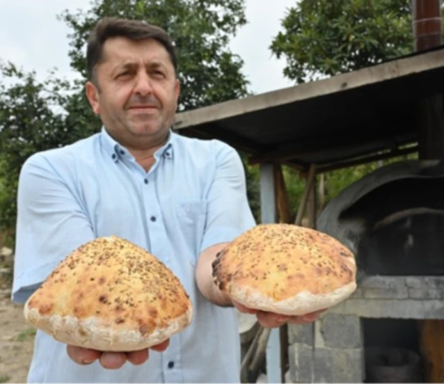 İmam taş fırında pişirdiği ekmekleri köylülere ikram ediyor