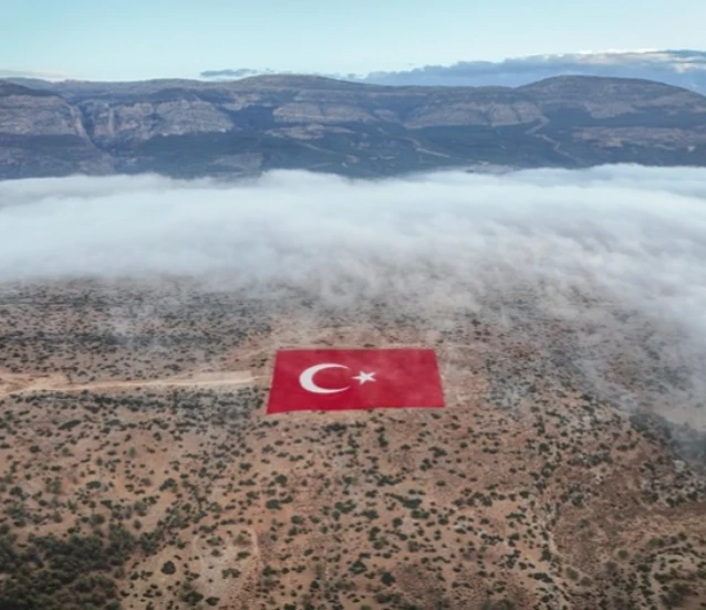 Mersin'de 22 dönümlük araziye işlenen Türk bayrağı siste görüntülendi